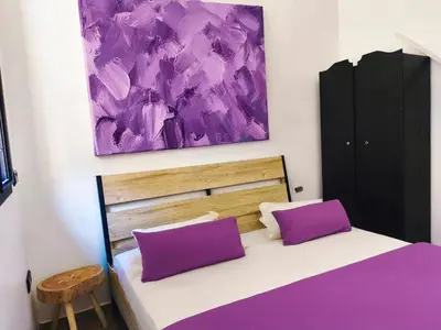 a bedroom with a purple painting above a bed at Hypercenter Comfy apartment Marrakech pool in Marrakech
