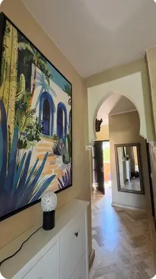 a living room with a large painting on the wall at Welcome to your Stylish Atlas View Apartment in Marrakech
