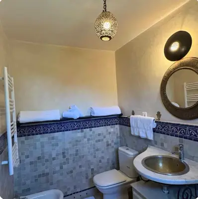 a bathroom with a sink and a toilet and a mirror at Welcome to your Stylish Atlas View Apartment in Marrakech