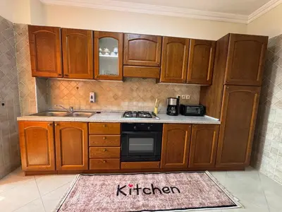 a kitchen with wooden cabinets and a kitchen rug at Appartement de luxe dans le centre de Marrakech in Marrakech