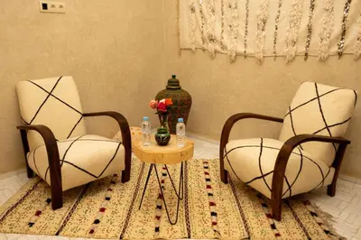 a room with two chairs and a table with a vase at Riad EL Mouloudi in Marrakech