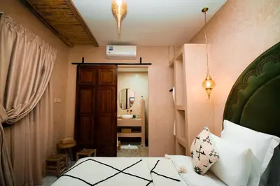 a bedroom with a bed and a bathroom with a sink at Riad EL Mouloudi in Marrakech