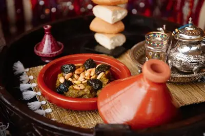 a red bowl of food on a table at Riad EL Mouloudi in Marrakech