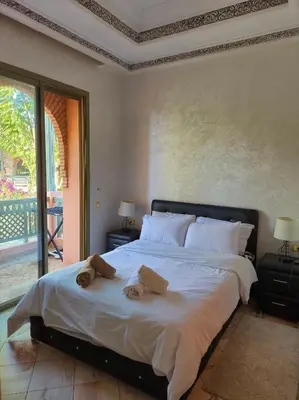 a bedroom with a large bed with towels on it at Oasis Garden Apartment Marrakech in Marrakech
