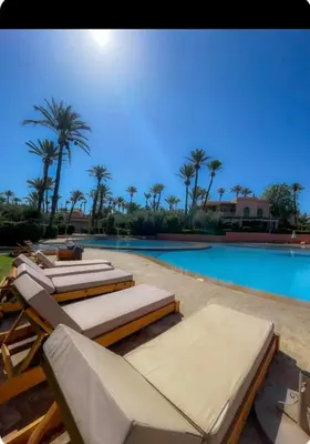 a swimming pool with several lounge chairs and a swimming pool at Oasis Garden Apartment Marrakech in Marrakech