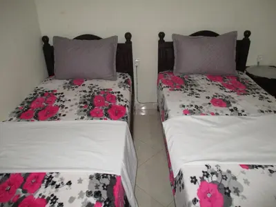 two beds sitting next to each other in a room at Joli spacieux apparrement in Marrakech