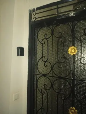 a black gate with a yellow flower on it at Joli spacieux apparrement in Marrakech