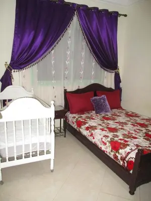 a bedroom with a bed with purple curtains at Joli spacieux apparrement in Marrakech