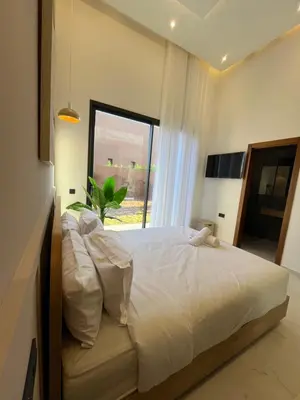 a bedroom with a large white bed with a window at Villa Signature in Marrakech