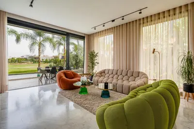 a living room with green furniture and a large window at Villa Kniza Luxury Stay, Courtyard, Pool and View in Marrakech