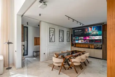 a dining room with a table and chairs and a tv at Villa Kniza Luxury Stay, Courtyard, Pool and View in Marrakech