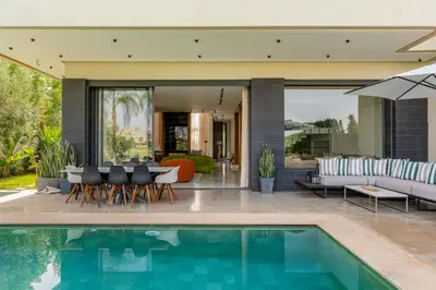 a house with a swimming pool and a patio at Villa Kniza Luxury Stay, Courtyard, Pool and View in Marrakech