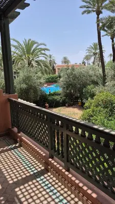 a fence with a pool in the background at Chic Palm Grove Apartment Pool View in Marrakech