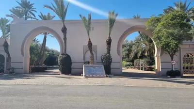 a building with three arches with palm trees in it at Chic Palm Grove Apartment Pool View in Marrakech