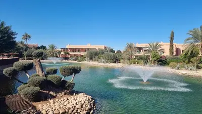 a fountain in the middle of a pool of water at Chic Palm Grove Apartment Pool View in Marrakech