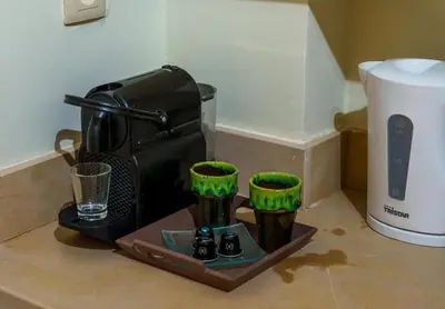 a coffee maker on a counter with green cups at Princess Gueliz center, Comfort, Quiet and View in Oulad Akkou