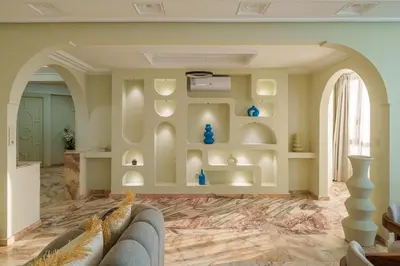 a living room with a couch and a wall with shelves at Princess Gueliz center, Comfort, Quiet and View in Oulad Akkou