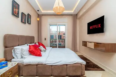 a bedroom with a bed with red pillows on it at Appart 2Ch Centre Marrakech in Marrakech