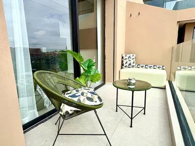 a balcony with a chair and a table at Lovely condo Marrakech city center terrasse garage in Marrakech