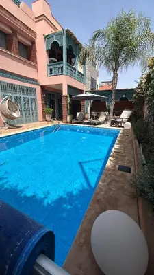 a large blue swimming pool in front of a building at Villa in marrakech city center with heated pool and breakfast inclued in Marrakech