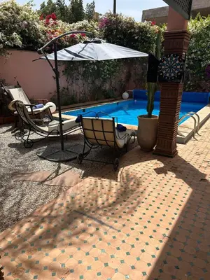 a swimming pool with a chair and an umbrella at Villa in marrakech city center with heated pool and breakfast inclued in Marrakech
