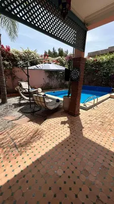 a patio with a chair and a swimming pool at Villa in marrakech city center with heated pool and breakfast inclued in Marrakech