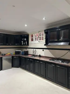a kitchen with black cabinets and a sink at Villa in marrakech city center with heated pool and breakfast inclued in Marrakech