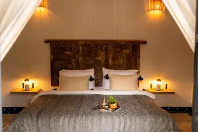 a bedroom with a large bed with two candles at Bab Akoul Palmeraie - Boutique Hotel & Spa in Marrakech