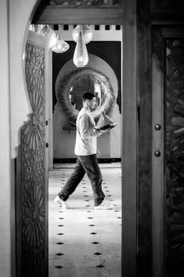 a man standing in front of a mirror with a book at Bab Akoul Palmeraie - Boutique Hotel & Spa in Marrakech