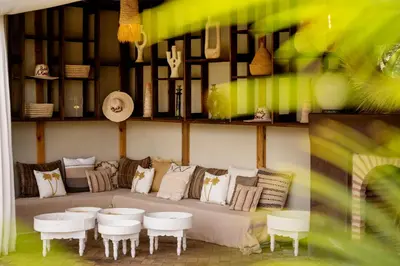 a living room with a couch and white tables and chairs at Bab Akoul Palmeraie - Boutique Hotel & Spa in Marrakech