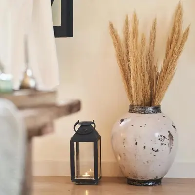 a candle sitting next to a vase with grass at Bab Akoul Palmeraie - Boutique Hotel & Spa in Marrakech