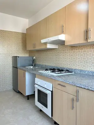 a kitchen with wooden cabinets and a stove top oven at Stunning 2BR in Top Location Marrakech City Center in Marrakech