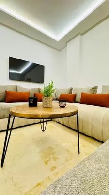 a living room with a couch and a table at Cozy luxury apartment downtown pool wifi fiber parking in Marrakech