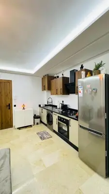 a kitchen with a refrigerator and a stove top oven at Cozy luxury apartment downtown pool wifi fiber parking in Marrakech