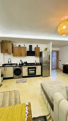 a living room with a kitchen and a couch at Cozy luxury apartment downtown pool wifi fiber parking in Marrakech