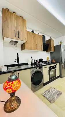 a kitchen with a sink and a table with a lamp at Cozy luxury apartment downtown pool wifi fiber parking in Marrakech