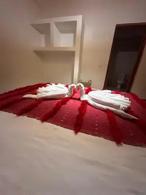 two towels on a bed with a red blanket at Villa Léa in Marrakech