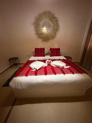 a bedroom with a bed with a red and white blanket at Villa Léa in Marrakech