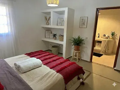 a bedroom with a bed with a red blanket on it at Villa Léa in Marrakech