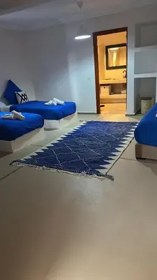 a room with two beds and a blue rug at Villa Léa in Marrakech