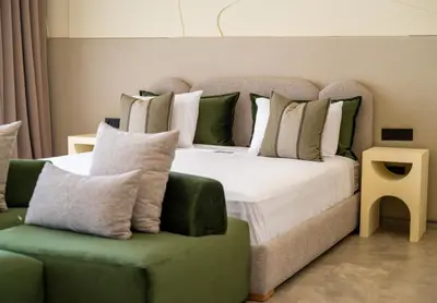 a bedroom with a large bed and a green chair at Berber Garden in Aït Amara