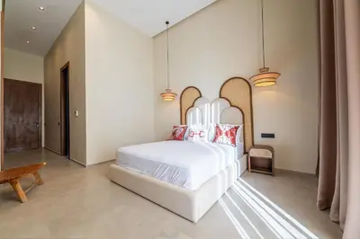 a bedroom with a large white bed with red pillows at Berber Garden in Aït Amara