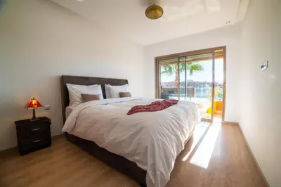 a bedroom with a large bed and a window at Prestigia golf city marrakech in Marrakech