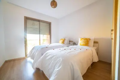 two beds in a white room with a window at Prestigia golf city marrakech in Marrakech