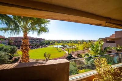 a view from the balcony of a resort with a palm tree at Prestigia golf city marrakech in Marrakech
