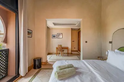 a bedroom with a bed and a table in a room at Luxury Beldi & Piscine at Villa Riad El Menzeh in Marrakech