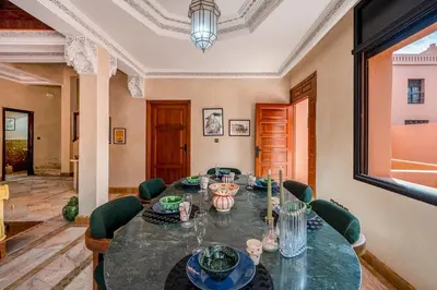 a dining room with a table and green chairs at Luxury Beldi & Piscine at Villa Riad El Menzeh in Marrakech