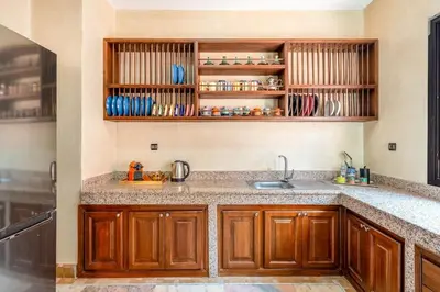 a kitchen with wooden cabinets and a sink at Luxury Beldi & Piscine at Villa Riad El Menzeh in Marrakech