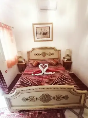 a bedroom with a bed with two swans on it at Riad DAR BARBI in Marrakech