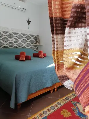 a bedroom with a bed with red pillows at Riad DAR BARBI in Marrakech